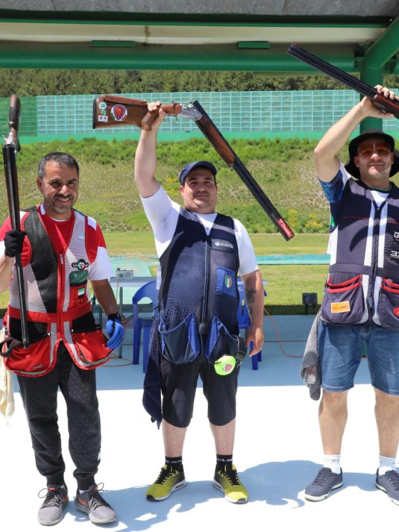 Three Para trop shooters standing with their shotguns after a competition